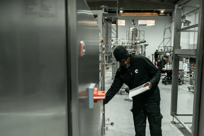 A man inspects equipment in a modern factory.